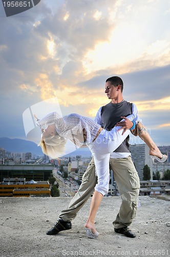 Image of romantic urban couple dancing on top of  bulding