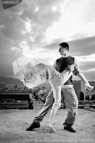 Image of romantic urban couple dancing on top of  bulding