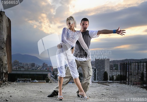 Image of romantic urban couple dancing on top of  bulding