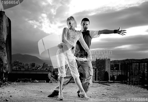 Image of romantic urban couple dancing on top of  bulding