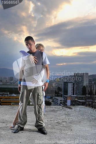 Image of romantic urban couple dancing on top of  bulding