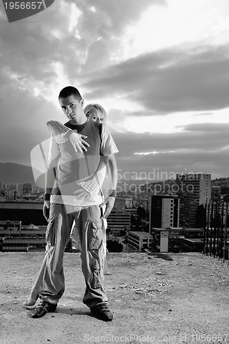 Image of romantic urban couple dancing on top of  bulding