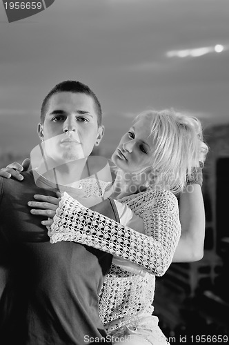 Image of romantic urban couple dancing on top of  bulding