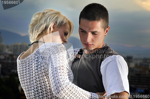 Image of romantic urban couple dancing on top of  bulding