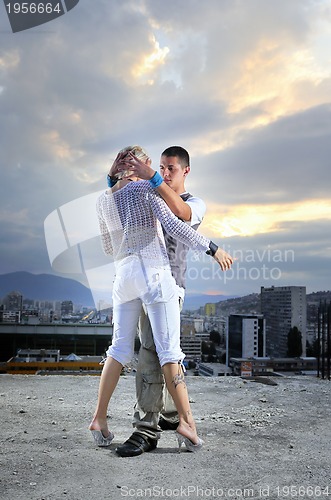 Image of romantic urban couple dancing on top of  bulding