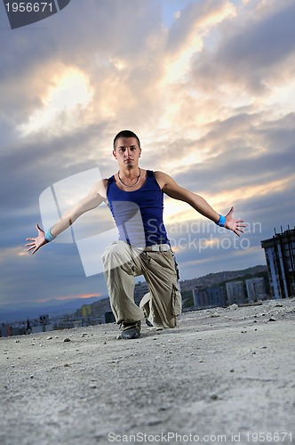 Image of young man jumping in air outdoor at night ready to party