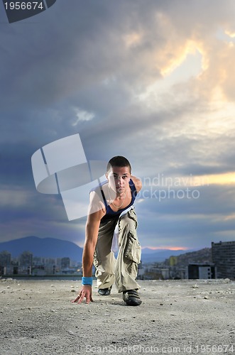 Image of young man jumping in air outdoor at night ready to party