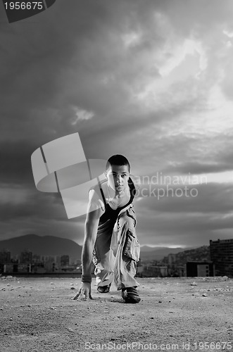 Image of young man jumping in air outdoor at night ready to party