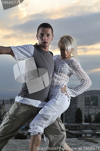 Image of romantic urban couple dancing on top of the bulding 