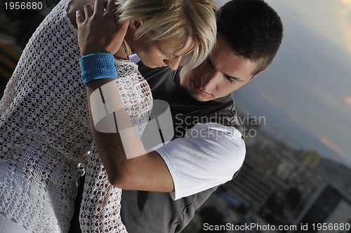 Image of romantic urban couple dancing on top of the bulding 