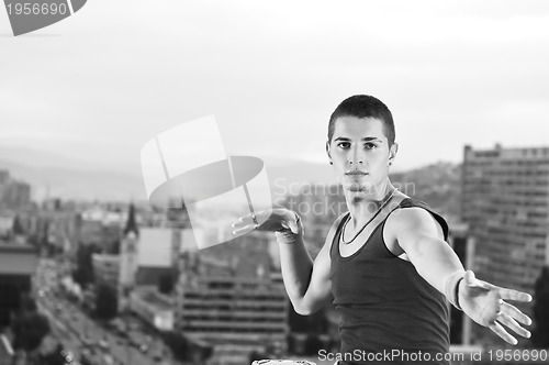 Image of young man jumping in air outdoor at night ready for party