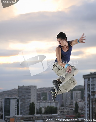 Image of young man jumping in air outdoor at night ready for party