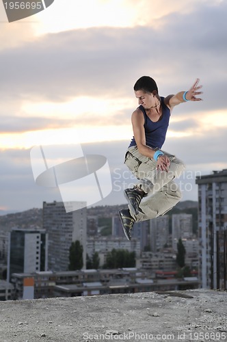 Image of young man jumping in air outdoor at night ready for party