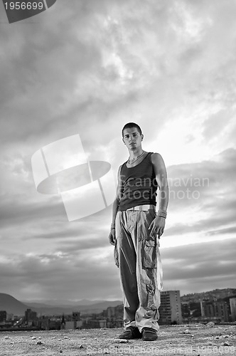 Image of young man dancing and jumping  on top of the building 