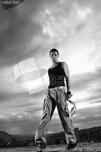 Image of young man dancing and jumping  on top of the building 