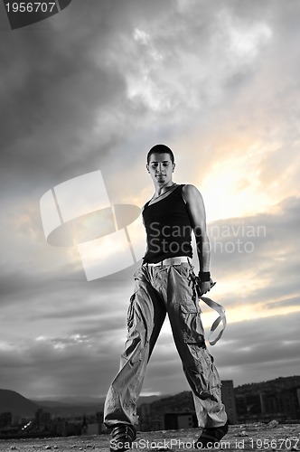 Image of young man dancing and jumping  on top of the building 