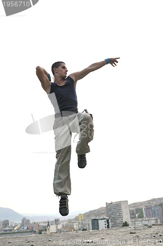 Image of young man jumping in air outdoor at night ready for party