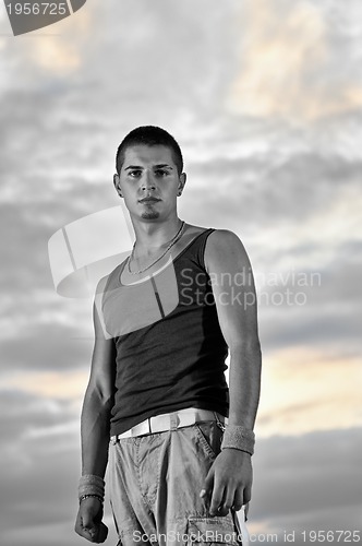 Image of young man dancing and jumping  on top of the building 