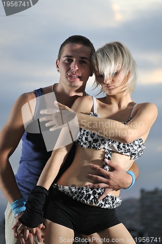 Image of romantic urban couple dancing on top of the bulding 