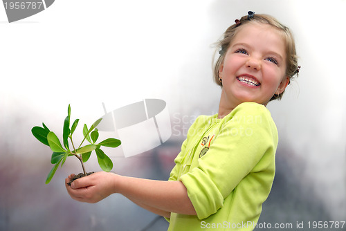 Image of little girl holding small plant