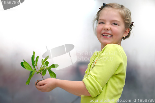 Image of little girl holding small plant