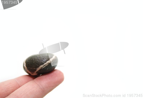 Image of .zen stone on finger representing balance concept