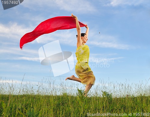 Image of beautiful woman with red scarf on meadow