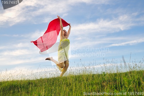 Image of beautiful woman with red scarf on meadow