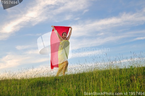 Image of beautiful woman with red scarf on meadow