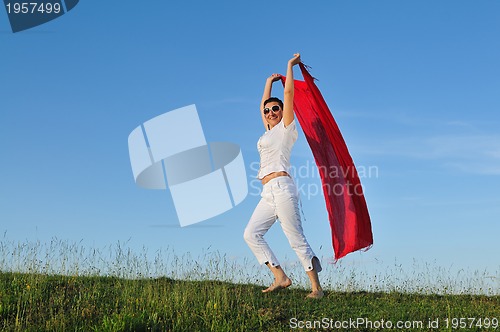 Image of beautiful woman with red scarf on meadow