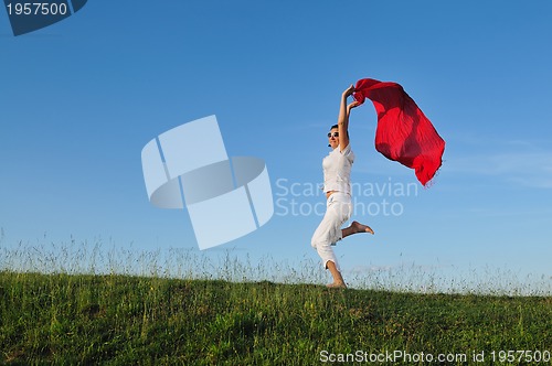 Image of beautiful woman with red scarf on meadow