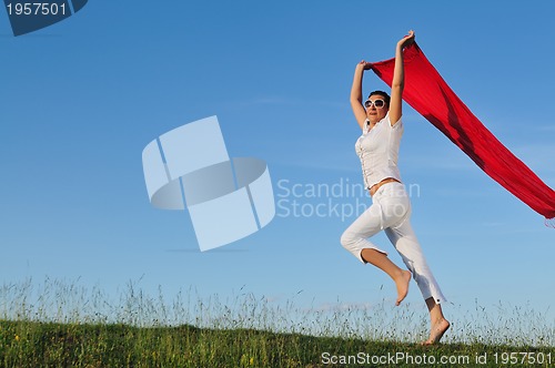 Image of beautiful woman with red scarf on meadow