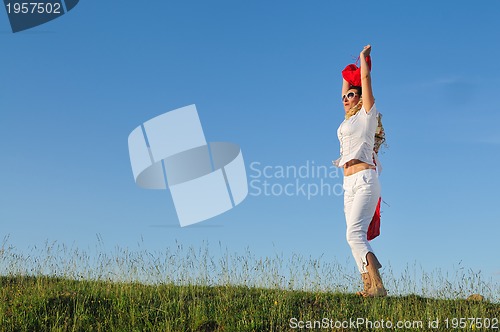 Image of beautiful woman with red scarf on meadow