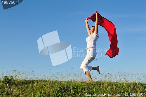 Image of beautiful woman with red scarf on meadow
