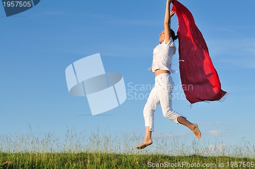 Image of beautiful woman with red scarf on meadow