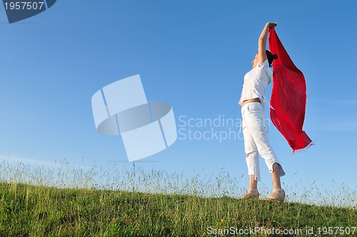 Image of beautiful woman with red scarf on meadow