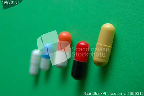 Image of pills on green background in row