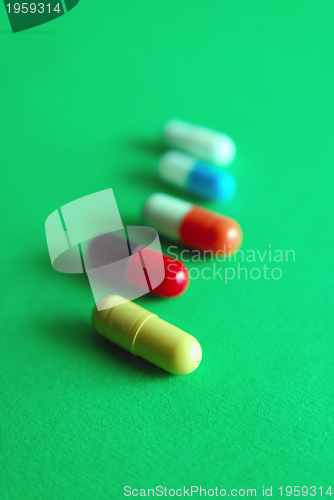 Image of pills on green background in row