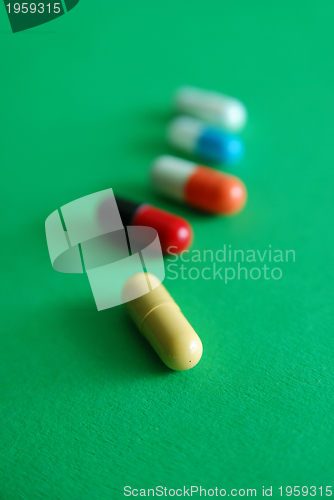 Image of pills on green background in row