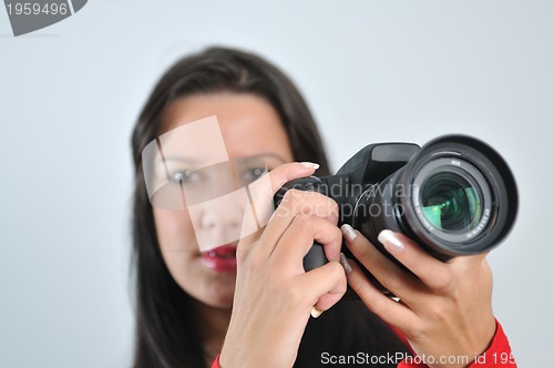 Image of Young woman holding camera in hand taking picture isolated