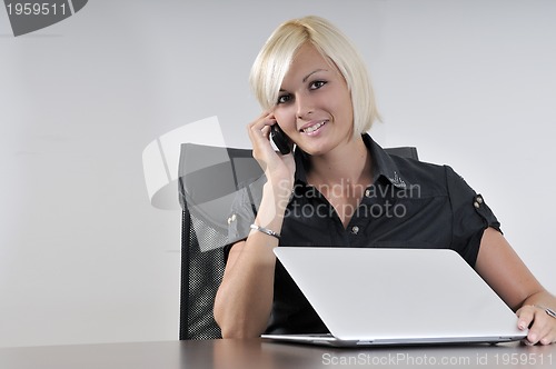 Image of  young business woman working in office on laptop