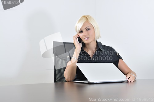 Image of  young business woman working in office on laptop