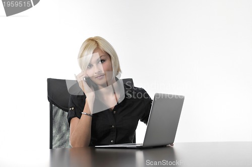 Image of  young business woman working in office on laptop