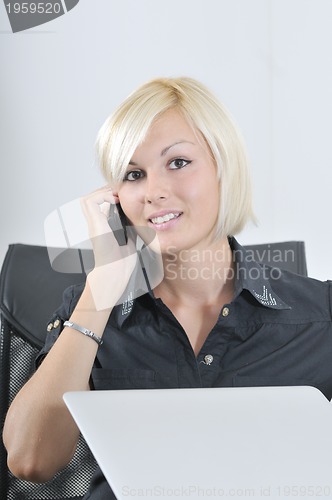 Image of  young business woman working in office on laptop