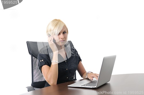 Image of  young business woman working in office on laptop