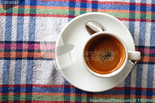 Image of Cup of coffee on a colorful tablecloth