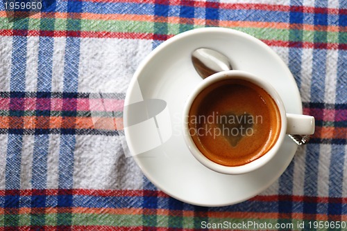 Image of Cup of coffee on a colorful tablecloth