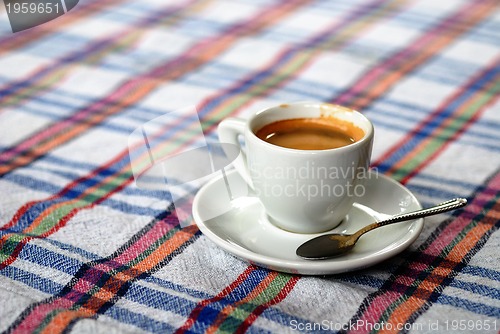 Image of Cup of coffee on a colorful tablecloth