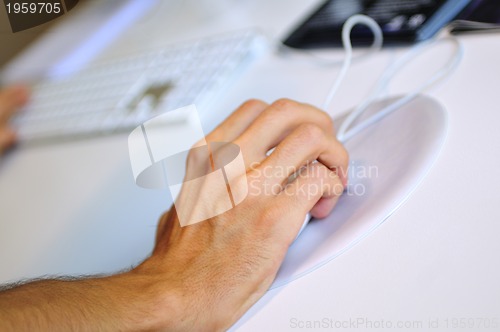 Image of lose-up of male hand on mouse while working on laptop