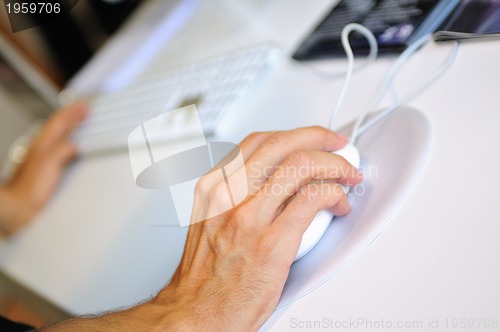 Image of lose-up of male hand on mouse while working on laptop